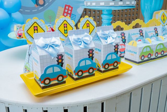 Caixinhas azuis com carrinhos e semáforos sobre bandeja amarela