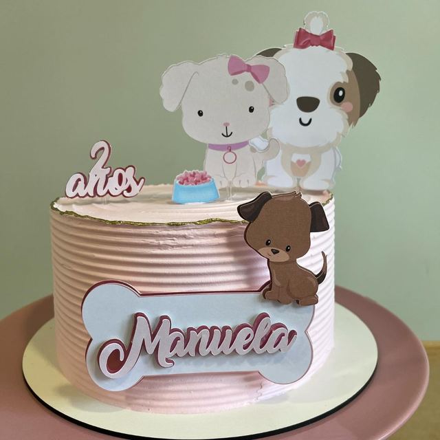Bolo rosa com topo de cachorrinhos, osso com o nome Manuela e 2 anos
