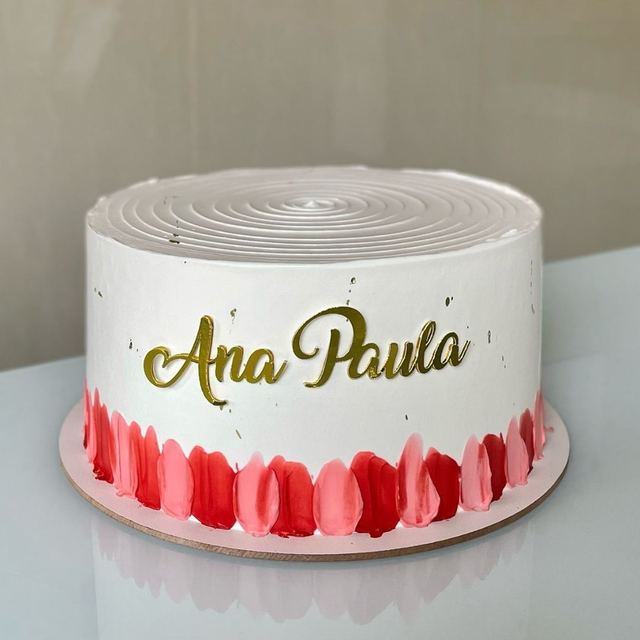 Bolo branco com nome em letras douradas